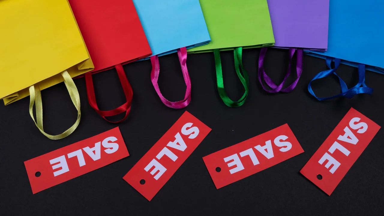 Colorful shopping bags with red sale price tags.